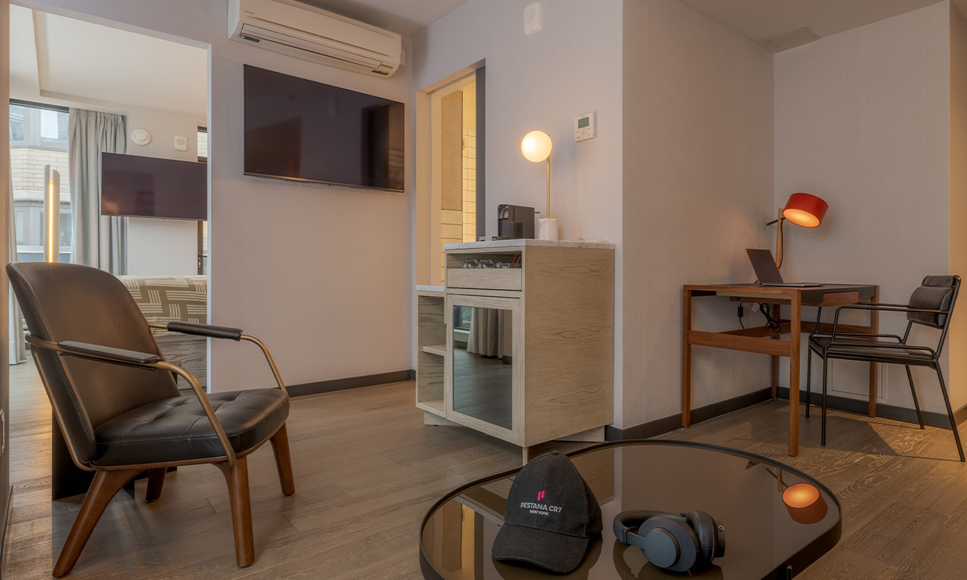 Een Junior Suite met Balkon en Uitzicht van Pestana CR7 Times Square heeft een bureau, een fauteuil, en koffiezetapparaat