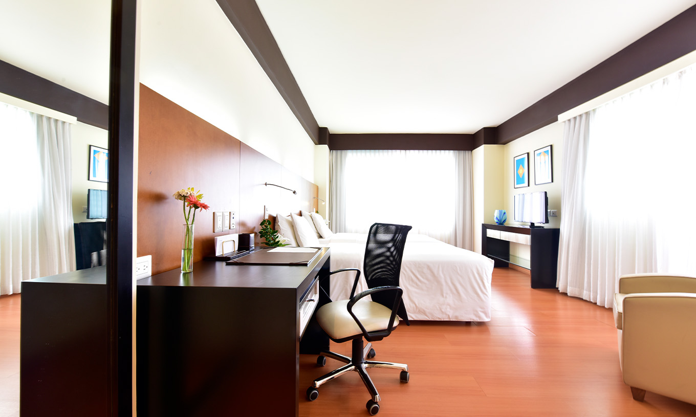 De Twin Junior Suite van Pestana Caracas heeft een tweepersoonsbed, bureau met ergonomische stoel en een televisie