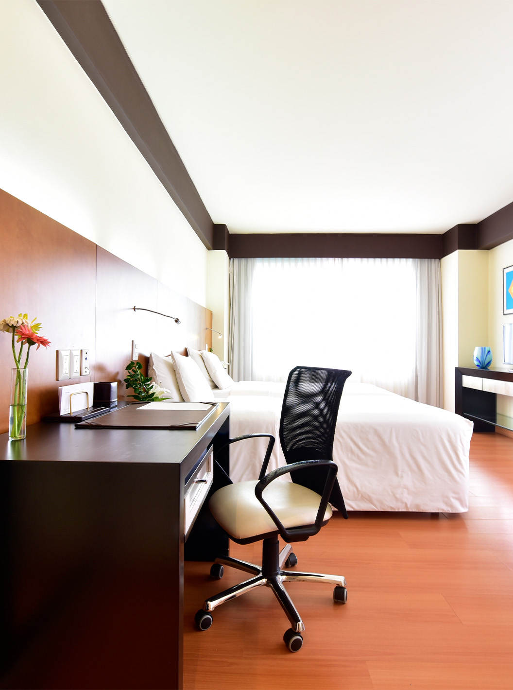 De Twin Junior Suite van Pestana Caracas heeft een tweepersoonsbed, bureau met ergonomische stoel en een televisie