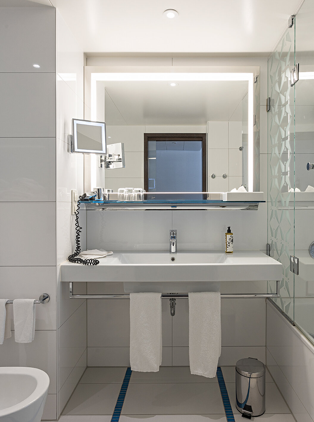 O Family Deluxe do Pestana Berlin Tiergarten tem uma casa de banho com banheira e duche, lavatório e espelho