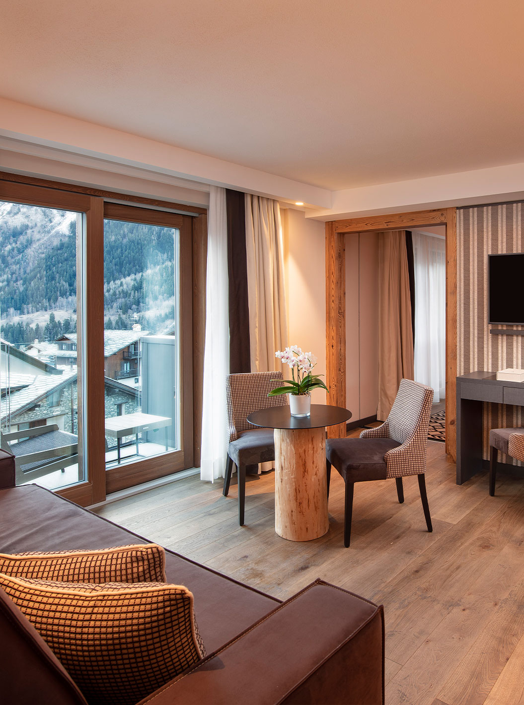 Suíte Vista Mont Blanc no Le Massif Courmayeur com sala aconchegante, mesa redonda e vista alpina das montanhas