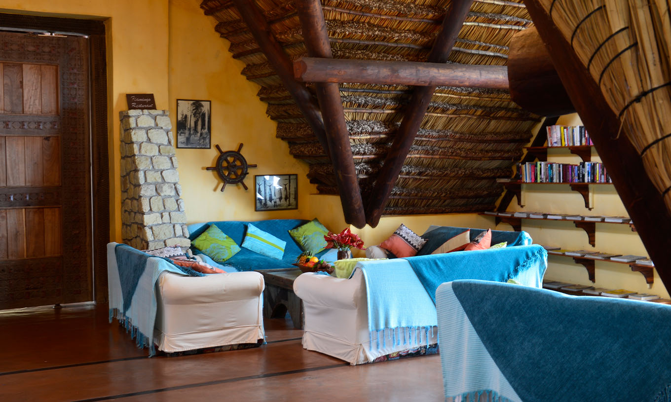 O Bungalow Suite T2 do Pestana Bazaruto Lodge tem uma sala ampla com sofás cobertos com mantas azuis e almofadas coloridas