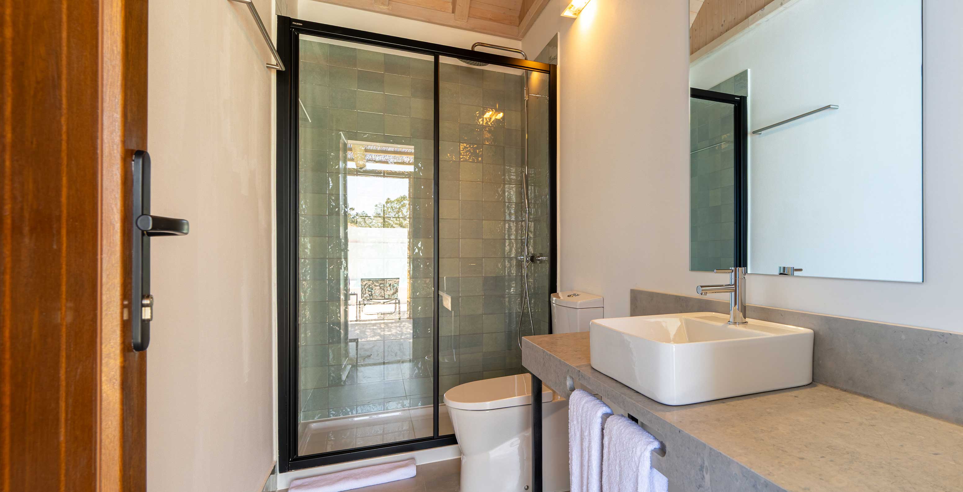 A Premium Villa do Pestana Comporta Village Residences tem uma casa de banho em tons cinza com um chuveiro