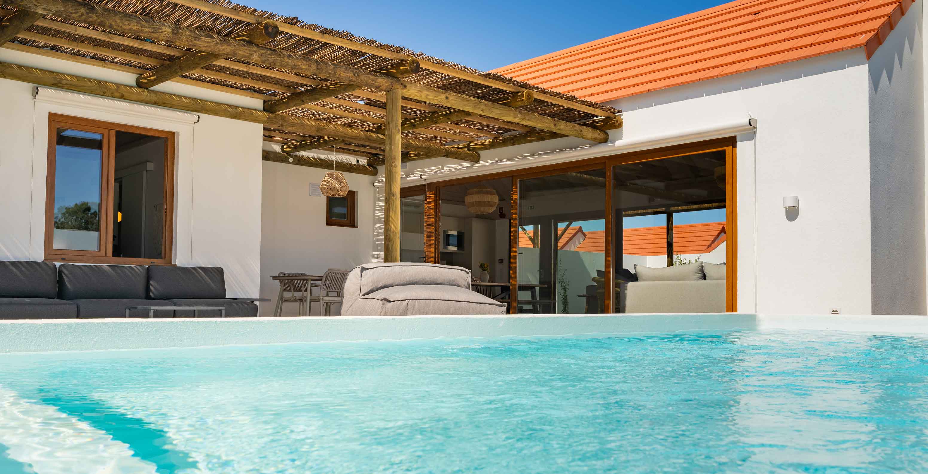 A Premium Green Villa do Pestana Comporta Village Residences tem uma piscina exterior, uma zona com sofás e uma mesa 