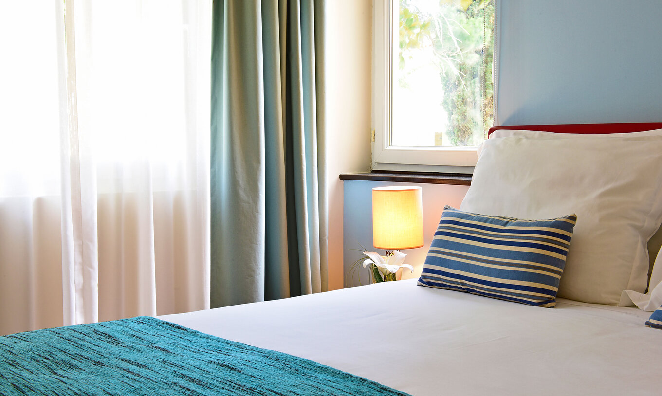 A Villa 2 Quartos Standard Vista Jardim do Pestana Alvor Beach Villas tem uma cama de casal com uma colcha azul
