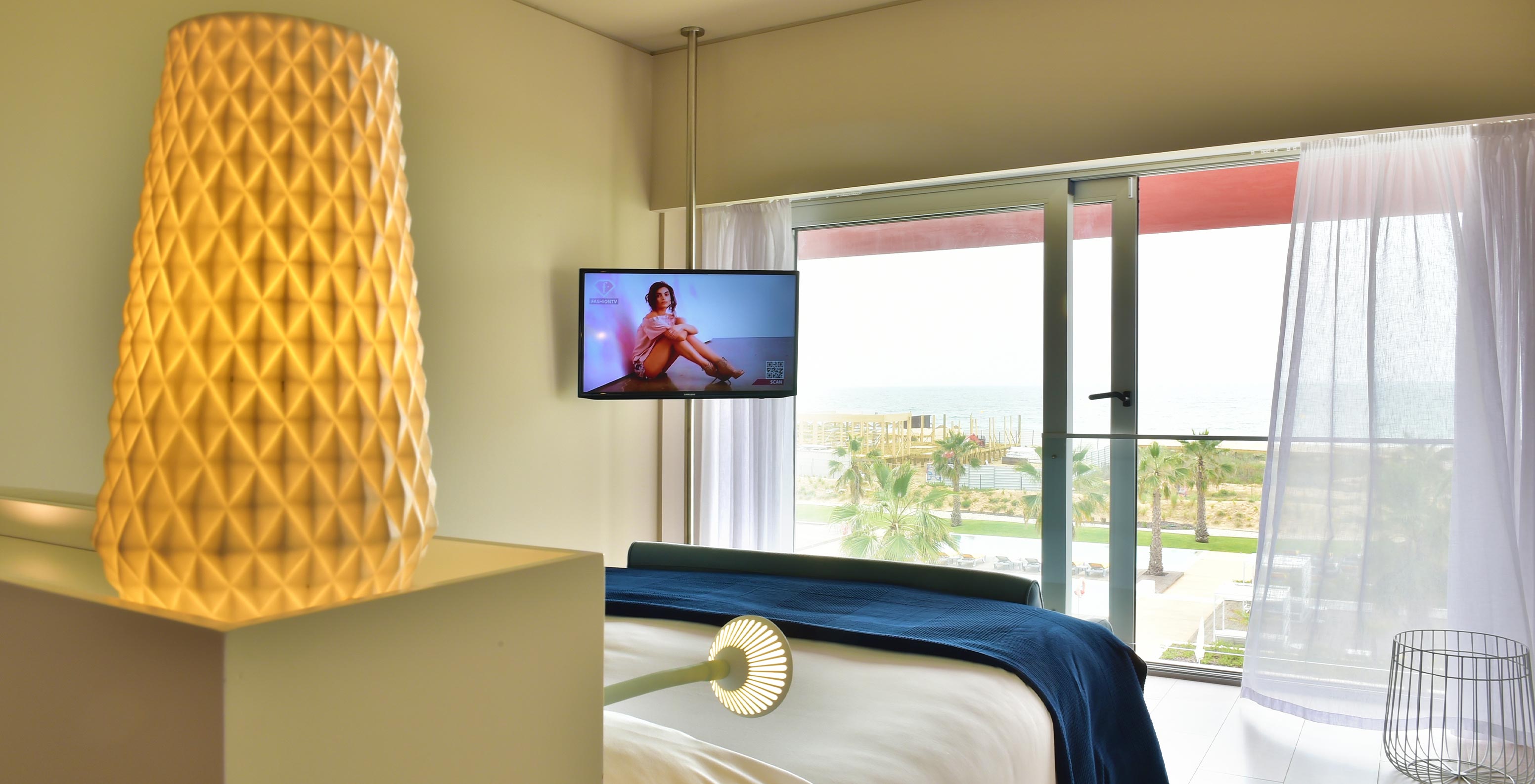 O Deluxe Vista Mar do Pestana Alvor South Beach tem uma varanda com mesa e cadeiras e vista para a piscina e para a praia
