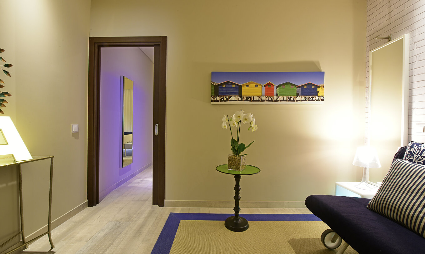 A Suite do Pestana Alvor South Beach tem uma pequena sala de estar com um sofá-cama. Decoração moderna e colorida