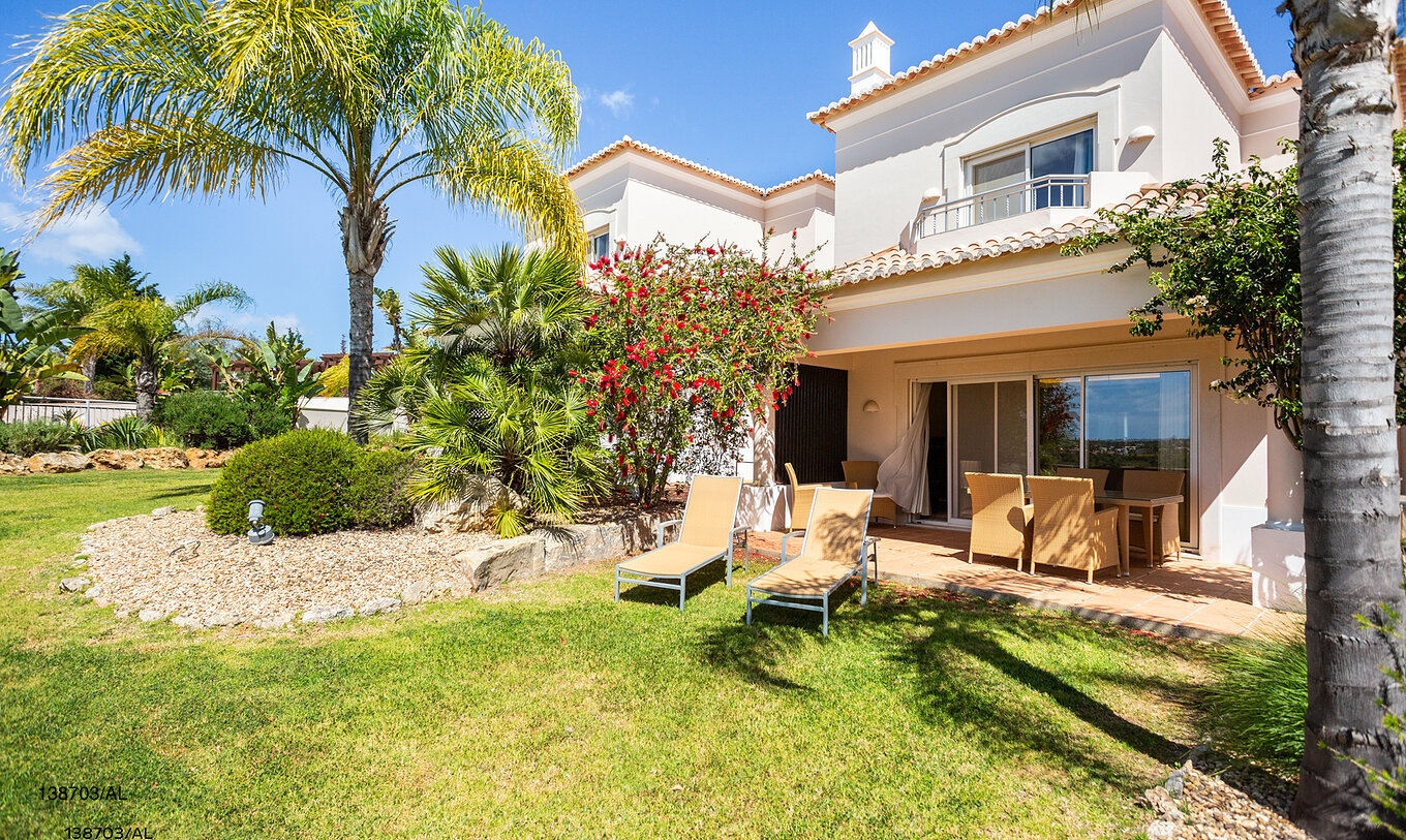 O Apartamento T2 Superior do Pestana Carvoeiro Golfe tem um pátio exterior com relva e espreguiçadeiras amarelas 