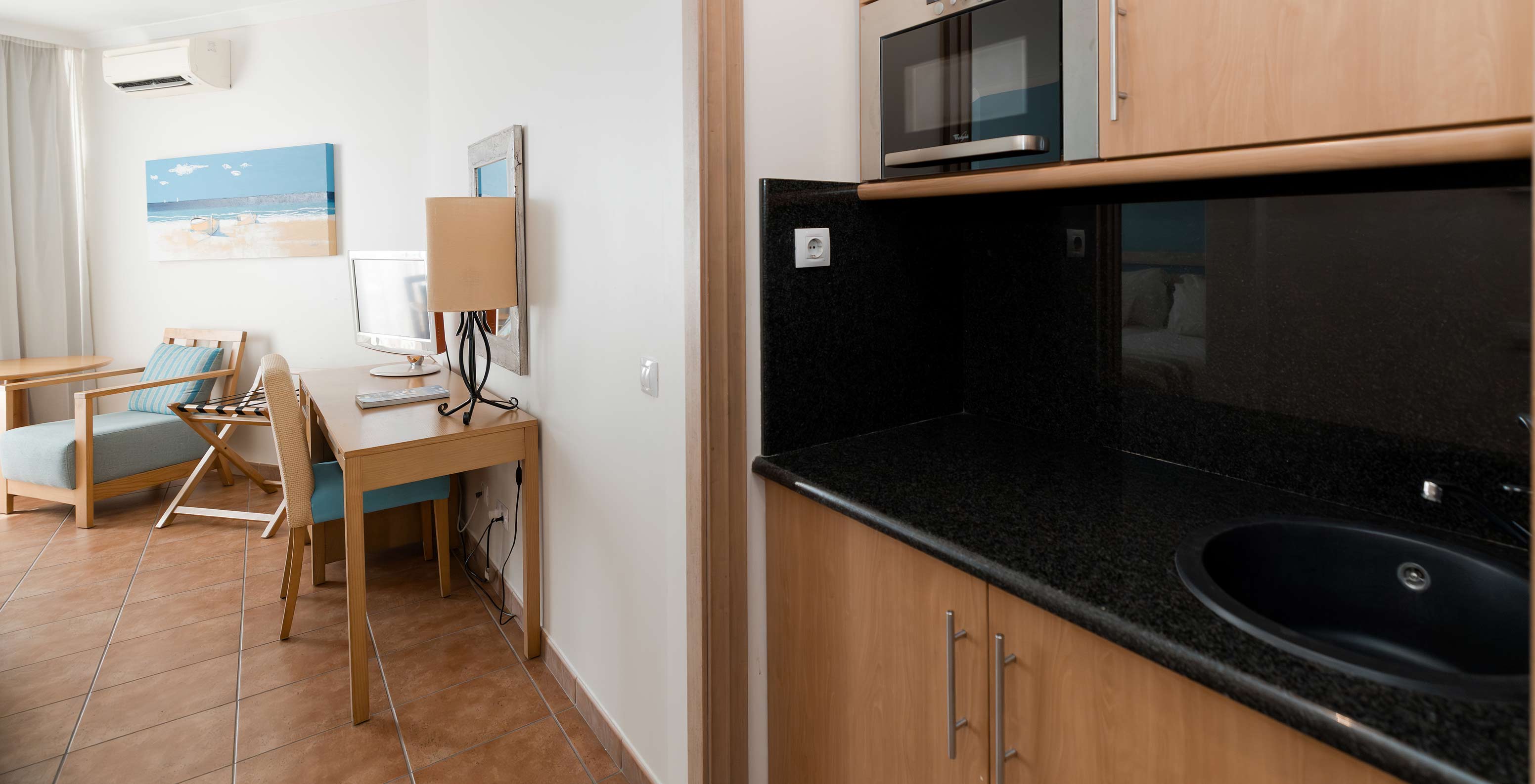 O Deluxe Vista Mar do Pestana Viking tem uma secretária e uma pequena cozinha, equipada com microondas e vários armários