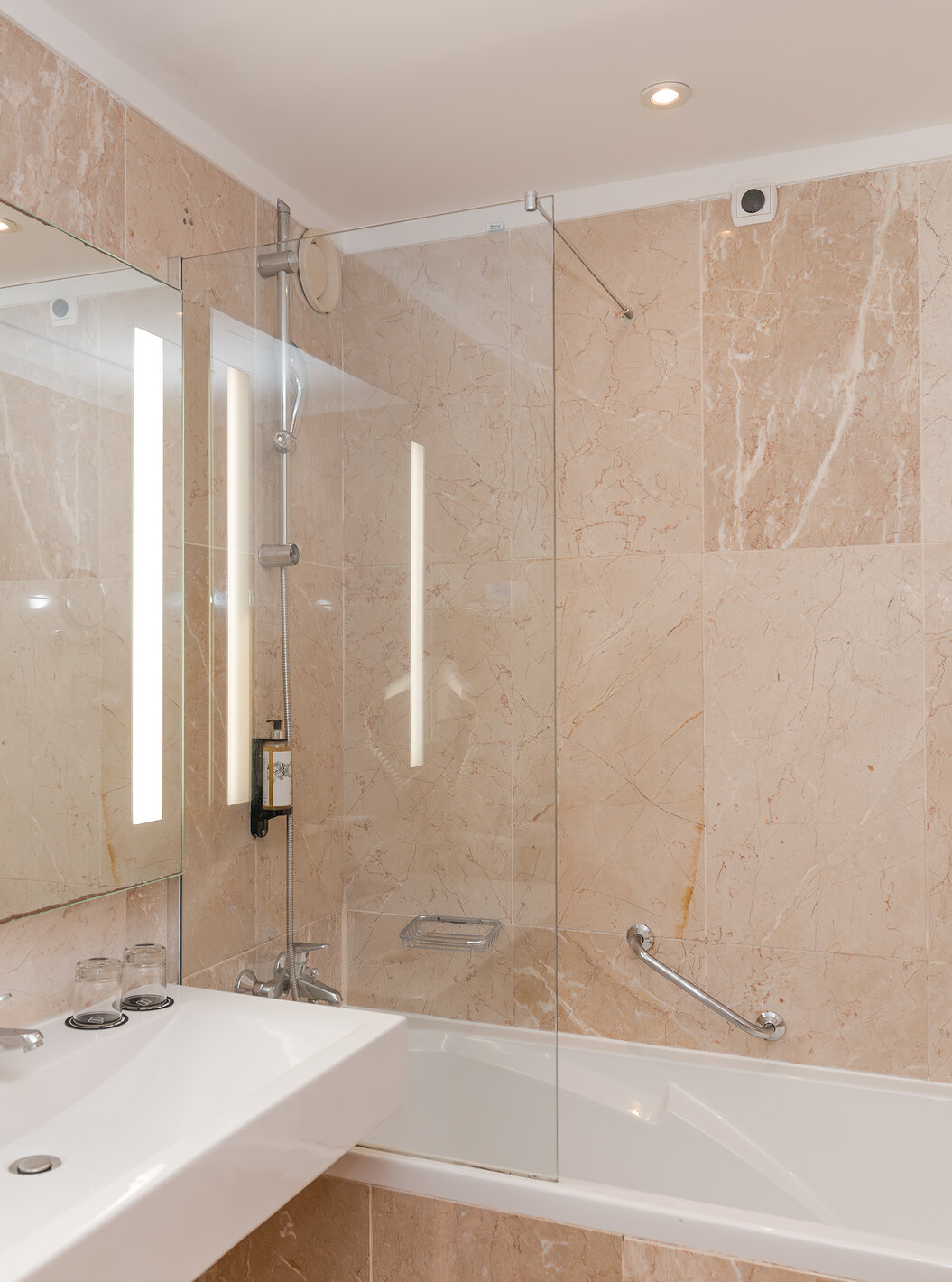 A Suite Vista Mar do Pestana Viking tem uma casa de banho com lavatório com espelho grande e uma banheira com duche