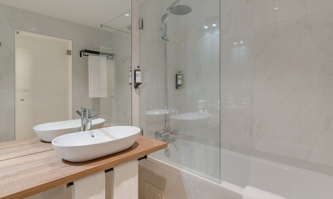 O Familiar - Clubhouse do Pestana Sintra Golf tem uma casa de banho moderna com banheira com duche e lavatório com espelho