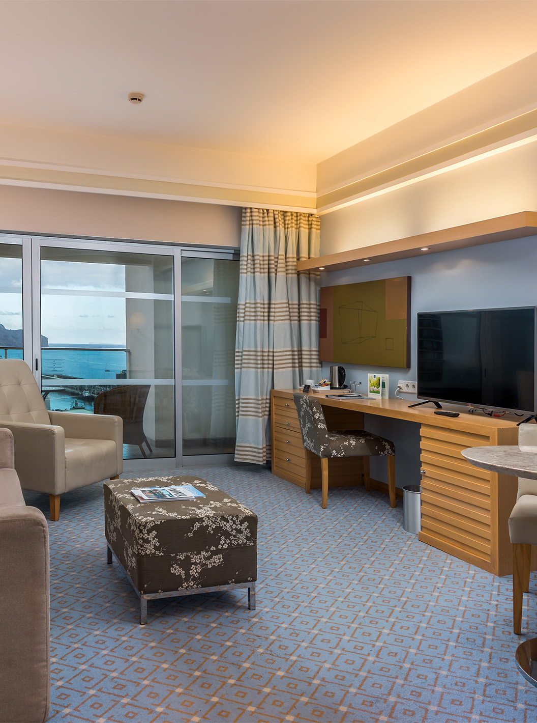 O Twin Clássico Vista Mar Superior do Pestana Carlton Madeira tem uma zona de estar com sofá, televisão, e uma varanda