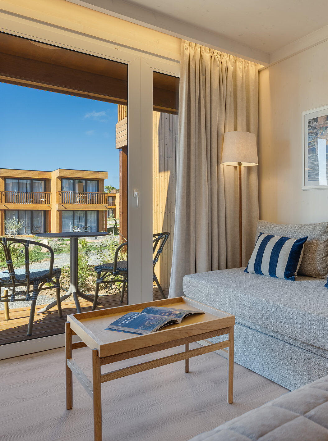 Quarto Familiar Eco Resort no Pestana Dunas Porto Santo ALL INCLUSIVE com sofá claro e varanda iluminada