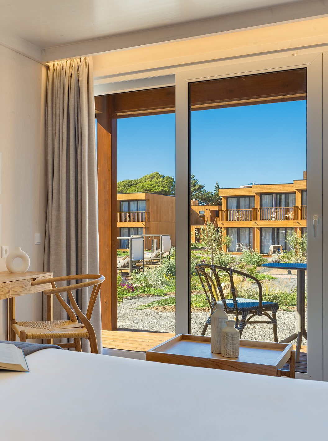 Quarto Familiar Eco Resort no Pestana Dunas Porto Santo ALL INCLUSIVE, com mesa de madeira e varanda iluminada