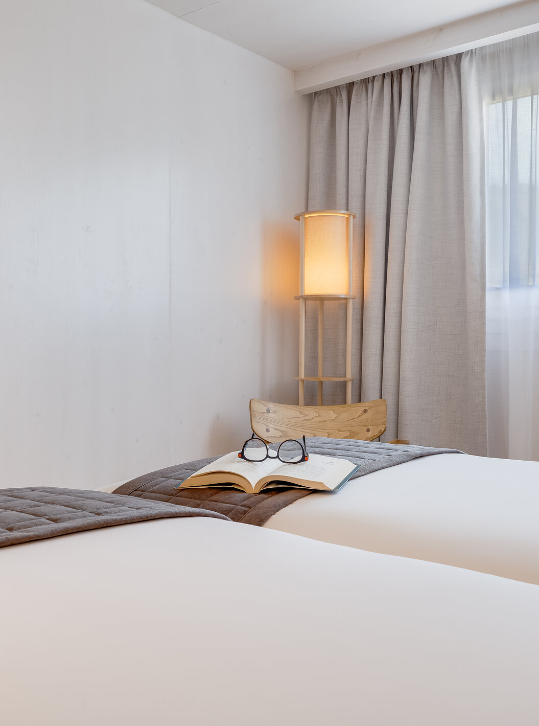 Suíte Eco Resort no Pestana Dunas Porto Santo ALL INCLUSIVE com camas claras, TV na parede e luminária suave