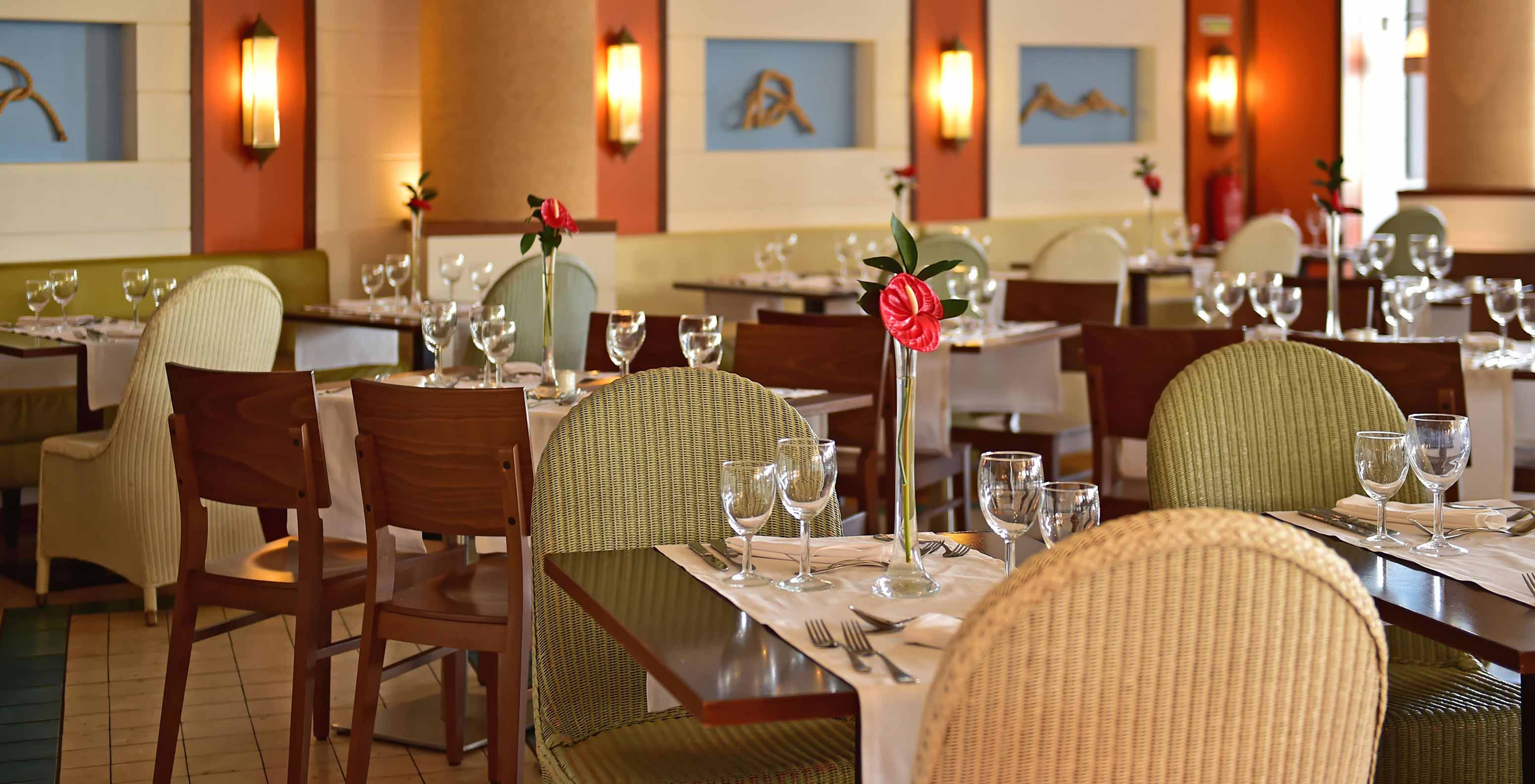 O restaurante Marés, do Resort de 5 Estrelas no Porto Santo tem um espaço com cadeiras verdes e mesas de madeira