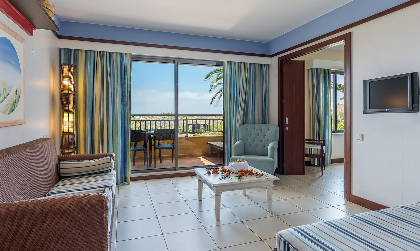 A Suite Apartamento T1 do Pestana Porto Santo All Inclusive tem uma sala com acesso à varanda, com vista para o jardim