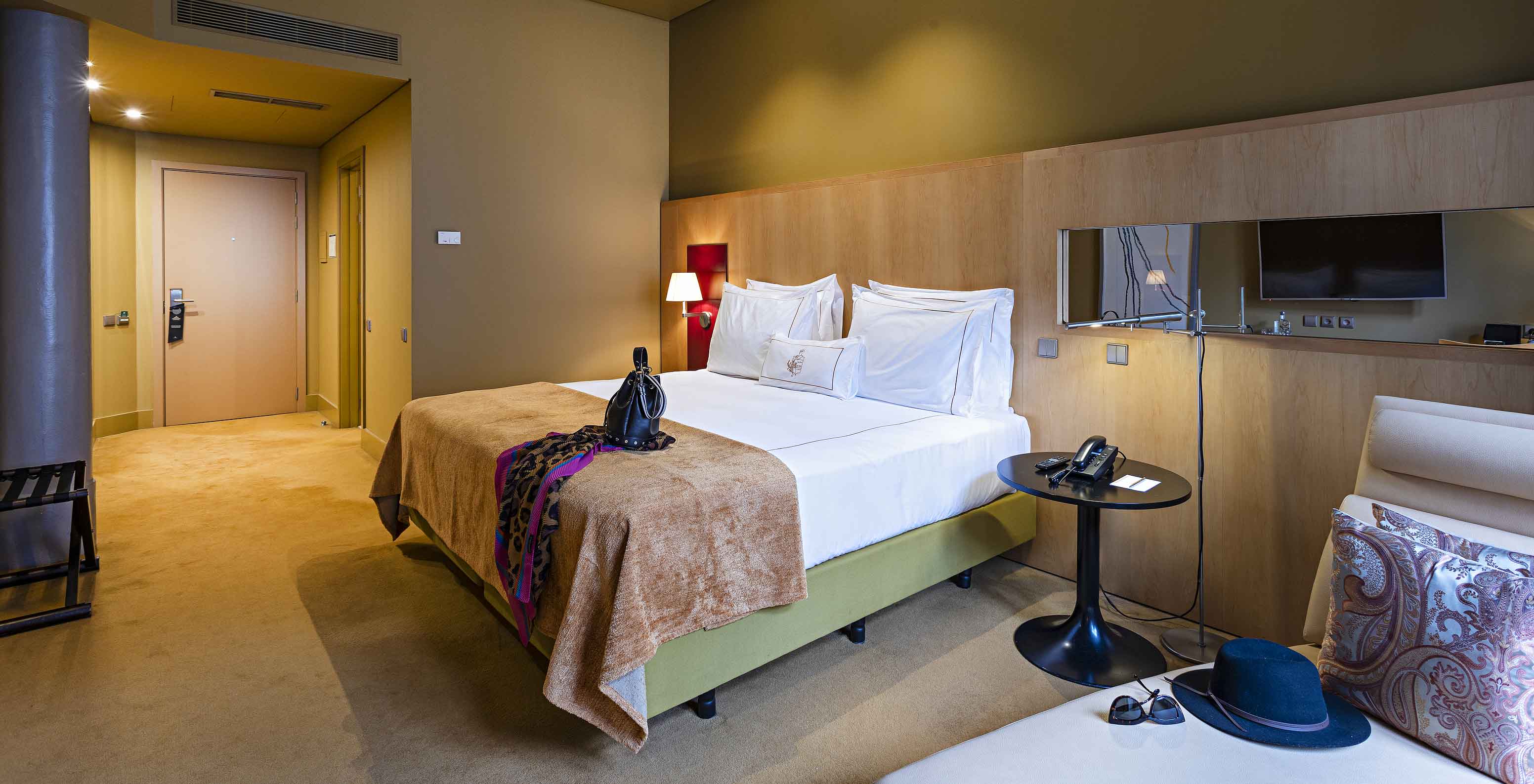 O Clássico do Pestana Palácio do Freixo tem uma cama de casal, um espelho, um sofá e uma janela com cortinas