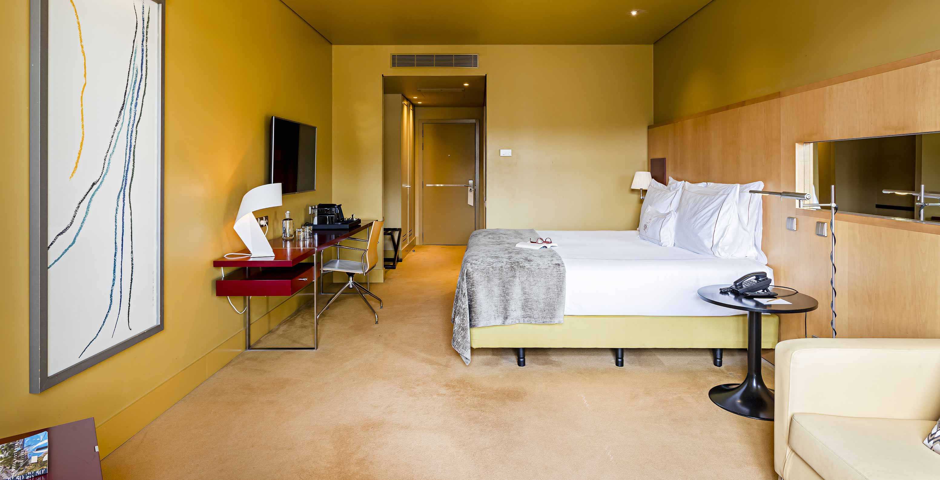 O Superior do Pestana Palácio do Freixo tem uma cama de casal com colcha cinzenta e uma secretária