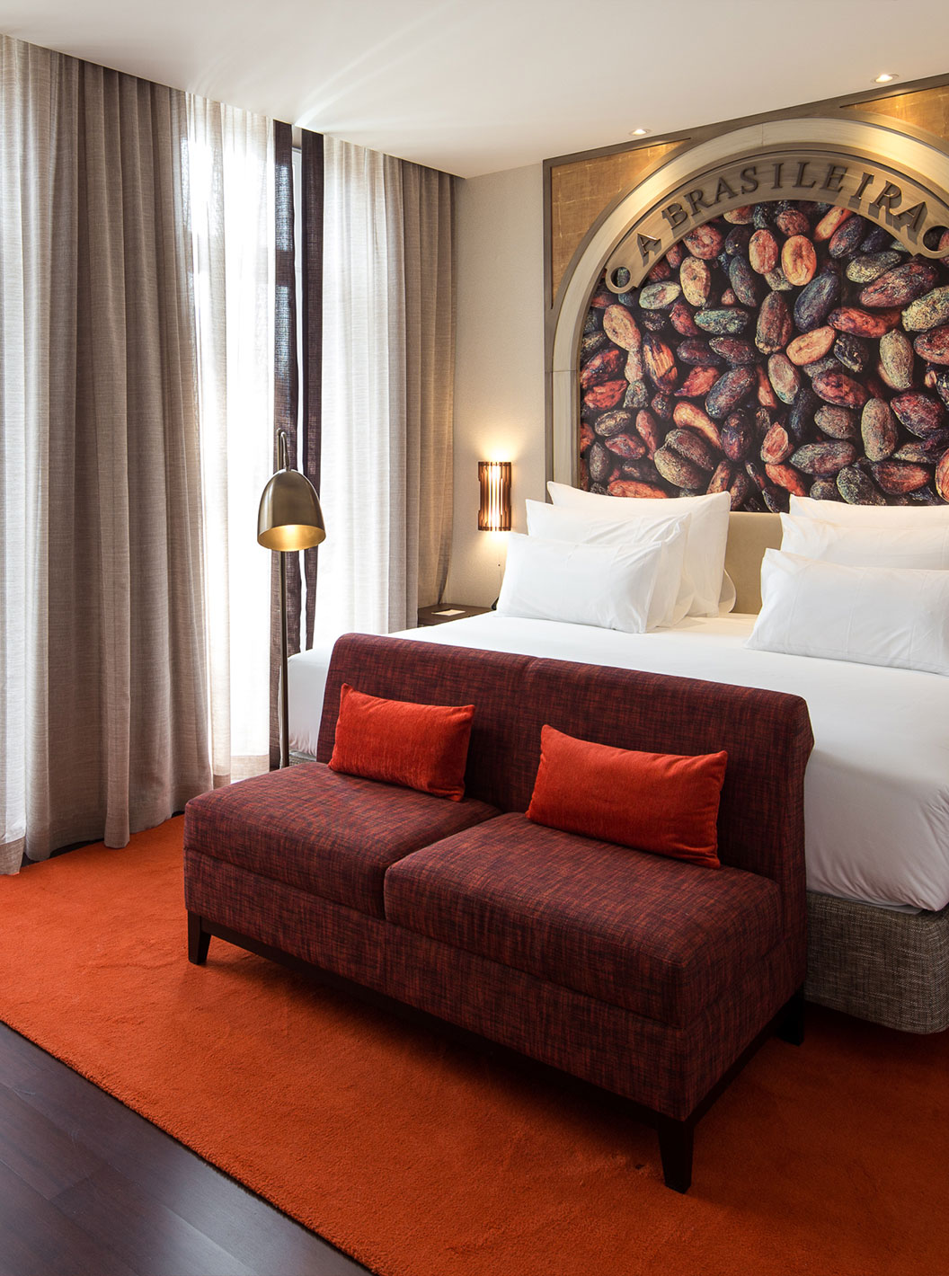 Quarto Premium Origin com Varanda Francesa no Pestana Porto - A Brasileira com cama ampla e sofá vermelho