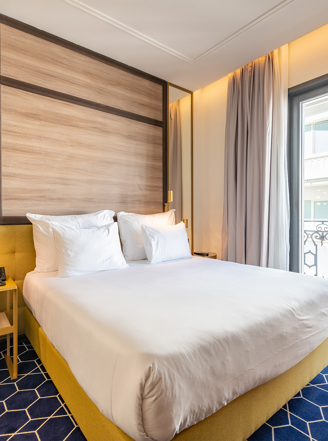 O Premium com varanda do Pestana CR7 Gran Vía Madrid tem cama de casal   janelas com vista para o edifício branco em frente