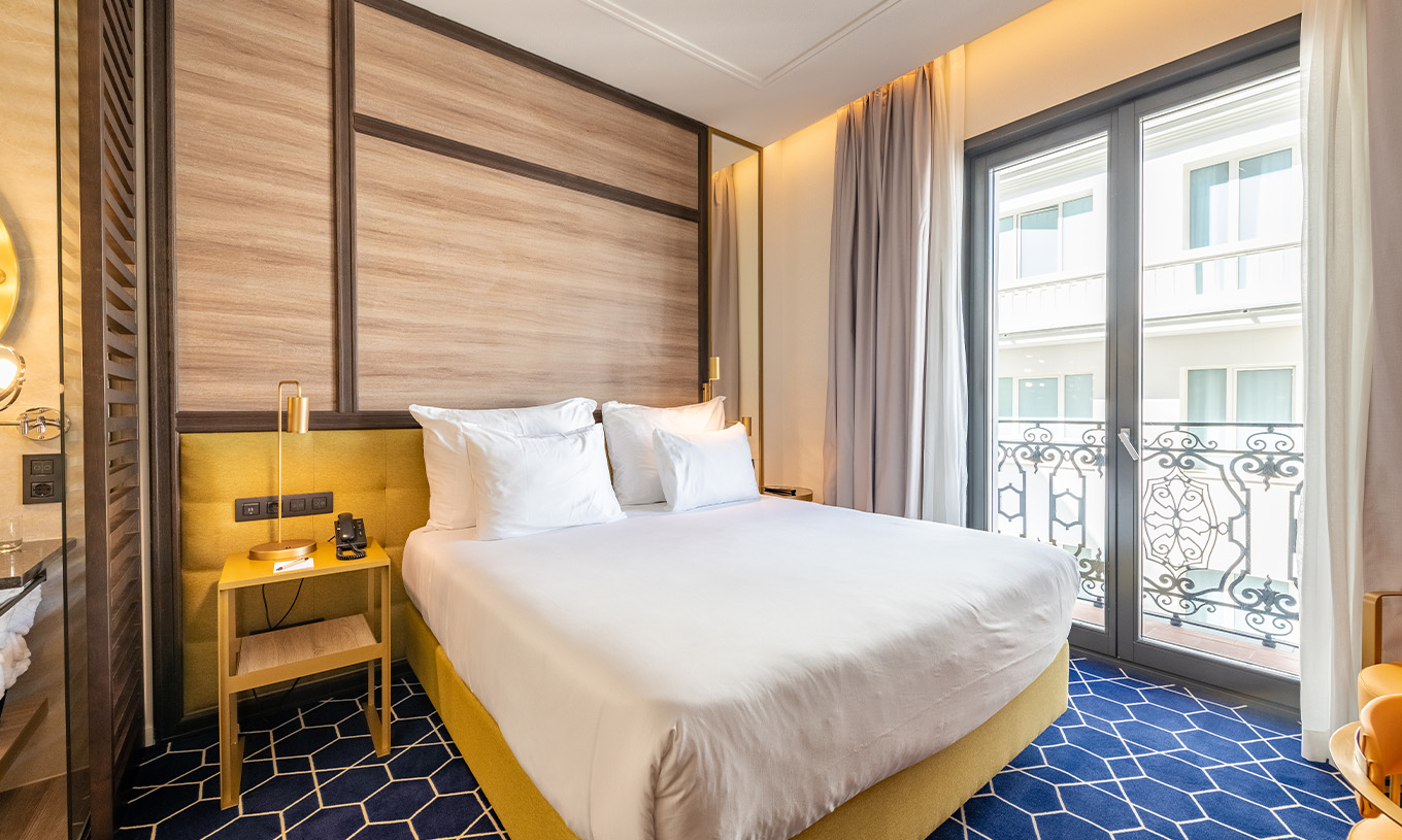 O Premium Grand com Varanda e Vista do Pestana CR7 Gran Vía Madrid tem cama de casal e janelas grandes para o edifício branco