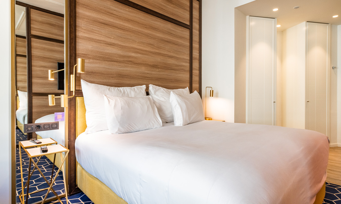 O The Fantastic 7 Room do Pestana CR7 Gran Vía Madrid tem cama de casal com mesa de cabeceira, candeeiros, espelho e armários