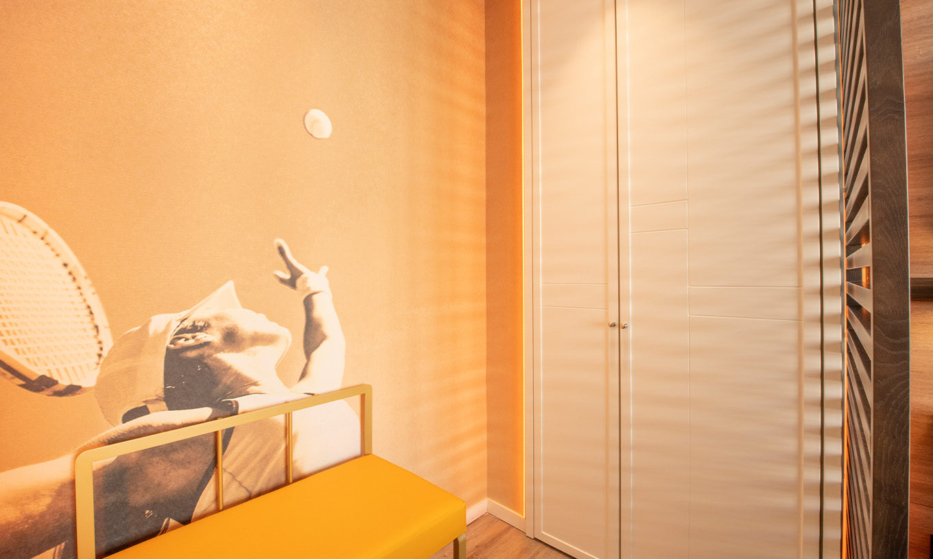 O The Legend Room do Pestana CR7 Gran Vía Madrid tem um armário, um banco e uma fotografia de um tenista como papel de parede