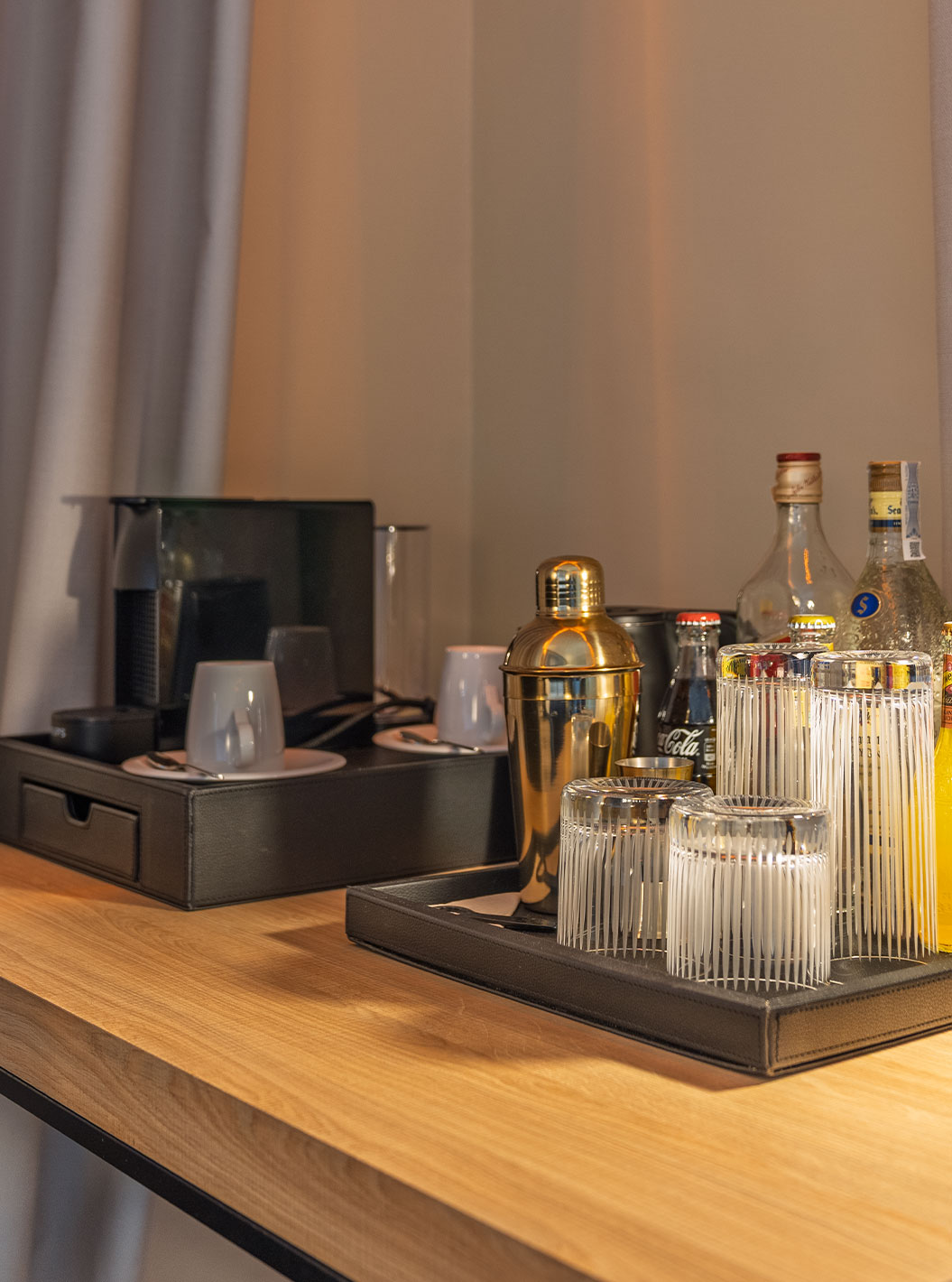Suíte Plaza Mayor no Pestana Collection Plaza Mayor, com cafeteira, bebidas e luminária sobre mesa de madeira