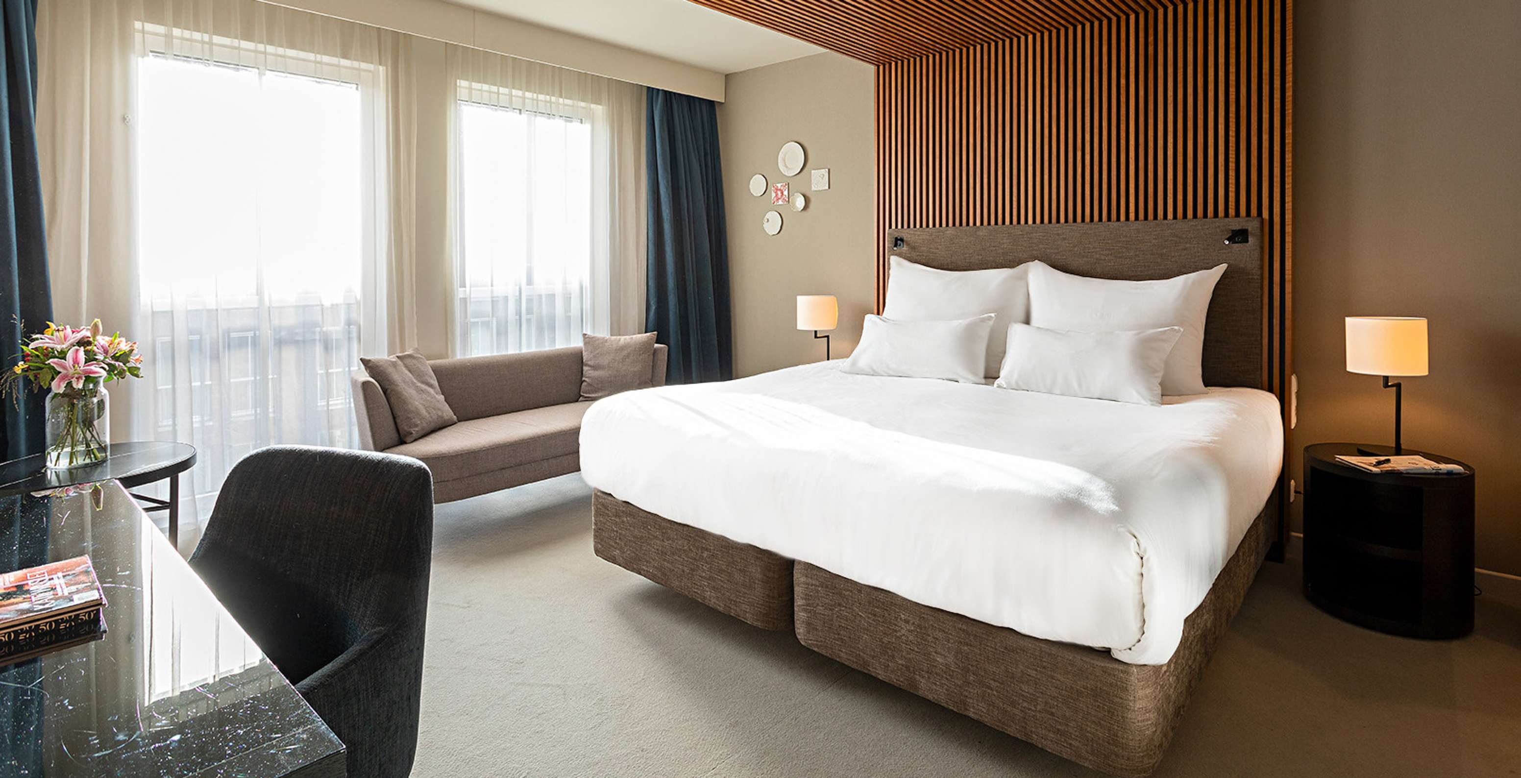 O quarto Superior do Pestana Amsterdam Riverside tem uma cama de casal, um sofá, e mesa de cabeceira com candeeiro