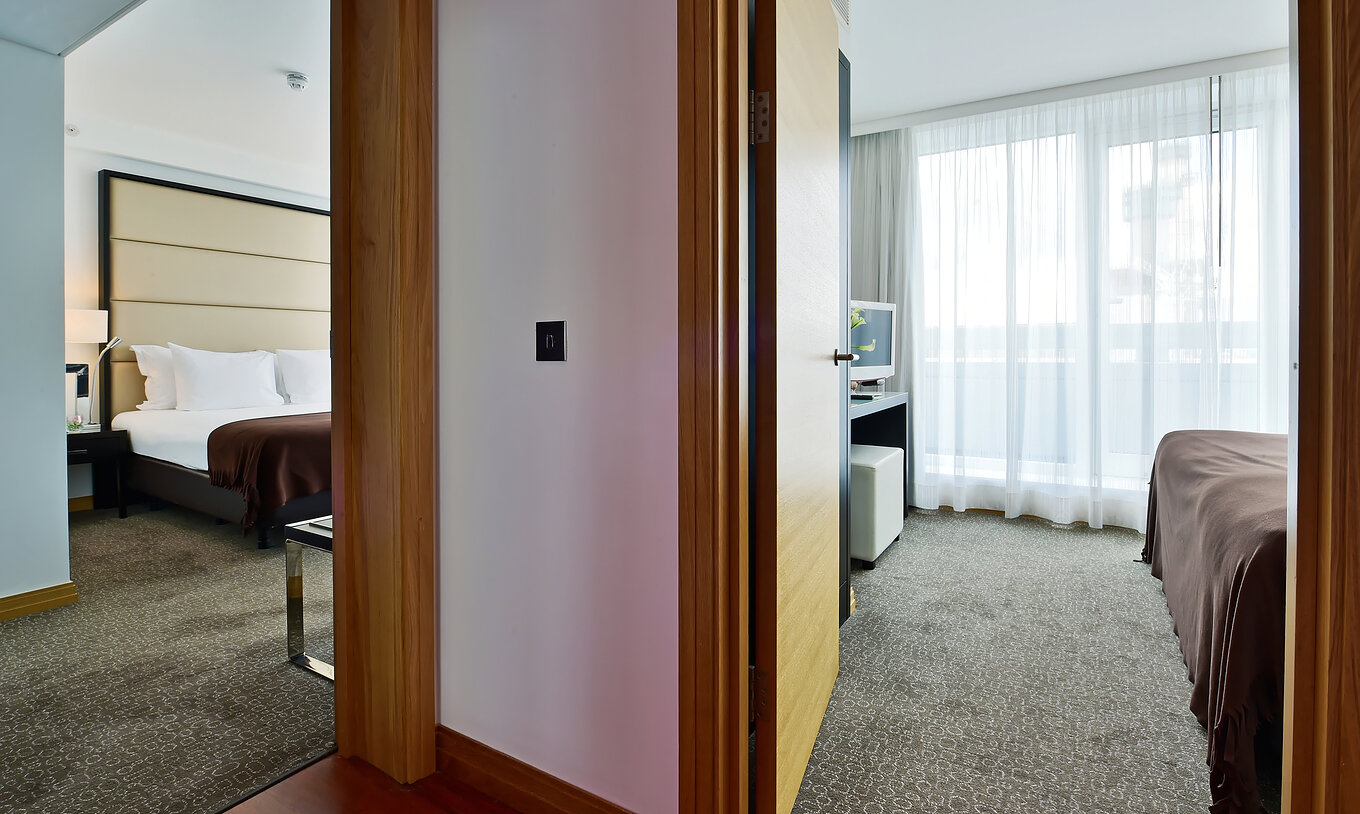 A Suite Executiva com 1 Quarto e Varanda do Pestana Chelsea Bridge tem uma grande janela com cortinas brancas e uma varanda privativa