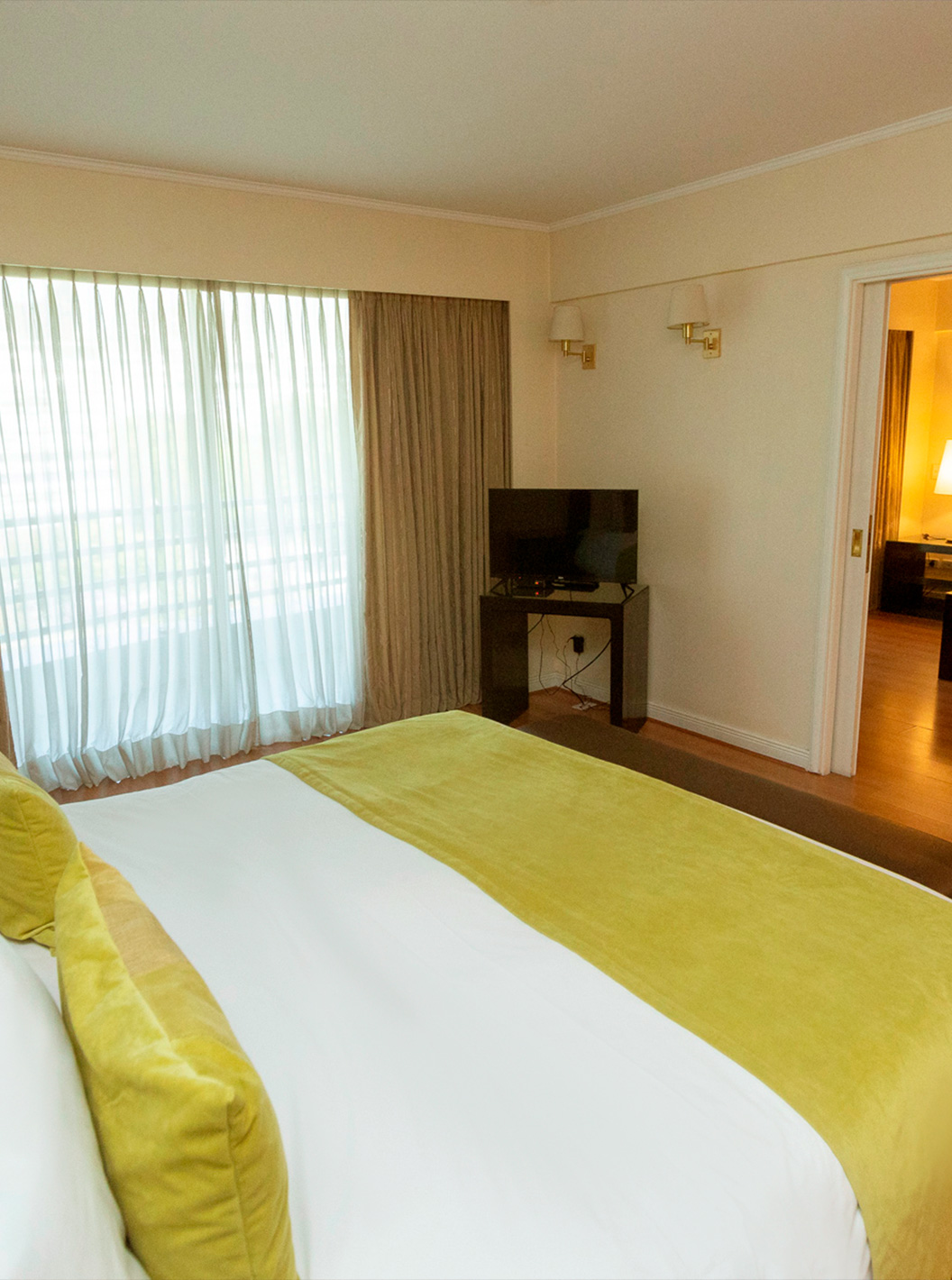 O quarto Queen Suite do Pestana Buenos Aires conta com uma cama de casal, candeeiro, televisão e sofá