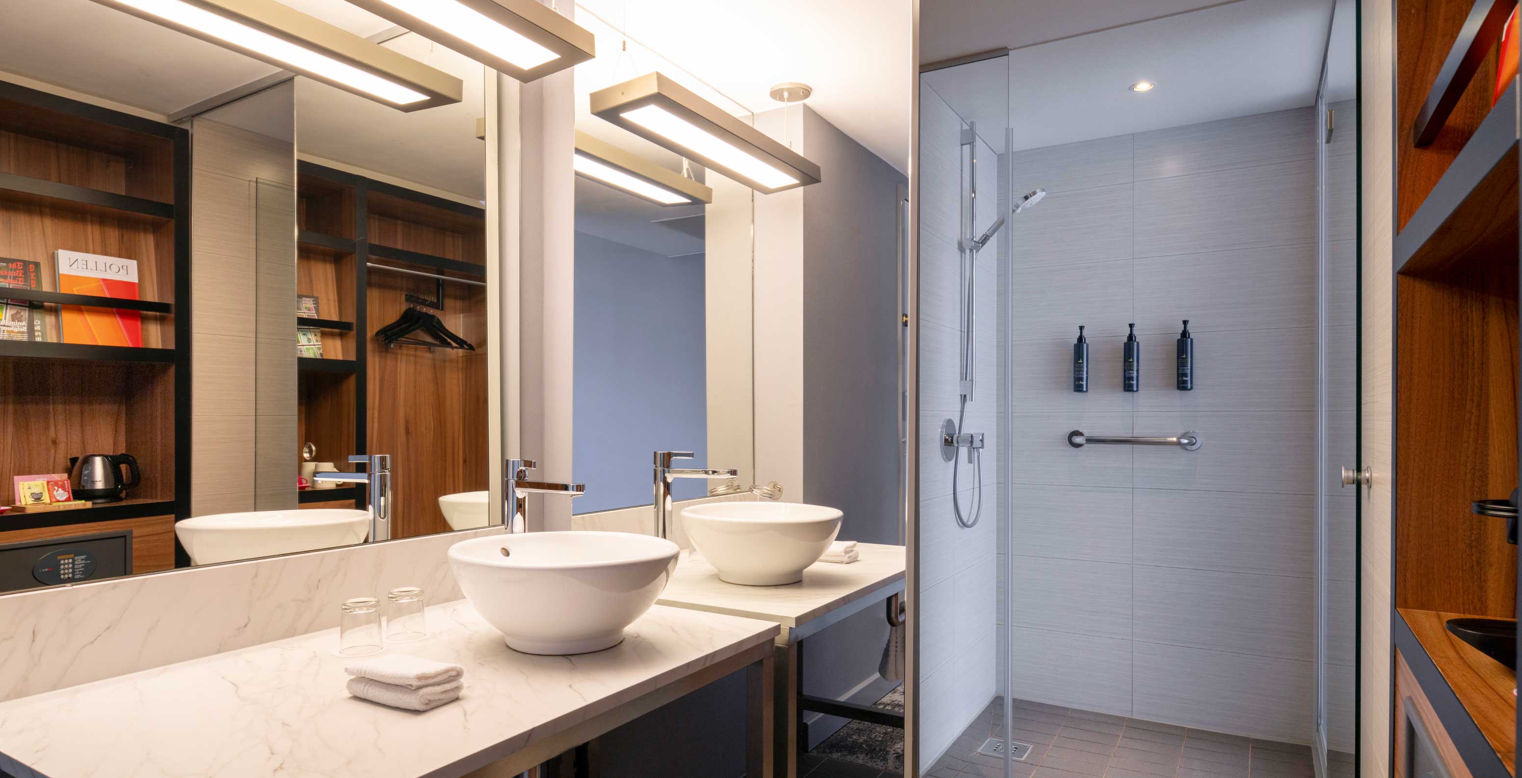 O Superior Familiar do Pestana Brussels Schuman tem uma casa de banho com um lavatório, um espelho grande e um chuveiro