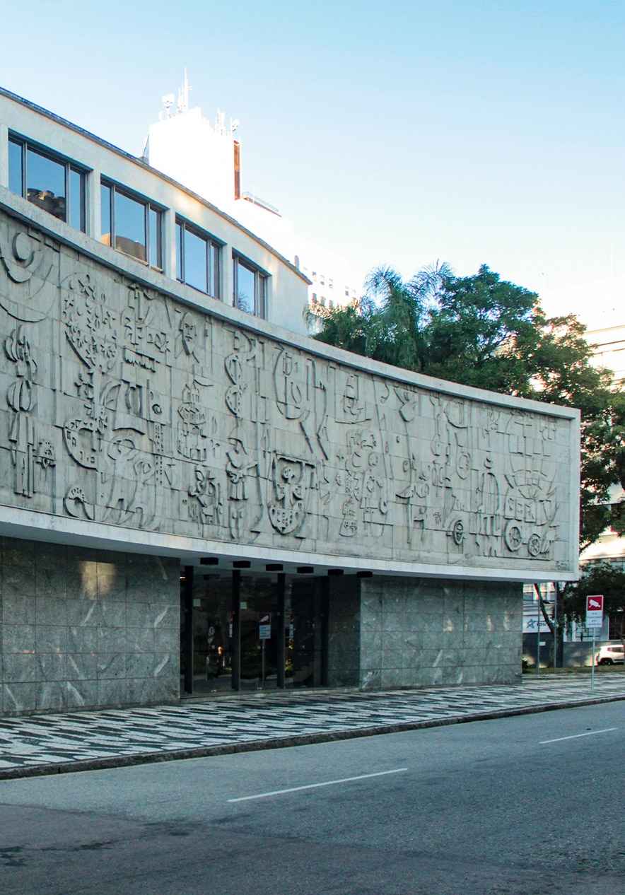 Festival de teatro em Curitiba junto a edifício moderno com fachada curva gravada e passeio calcetado