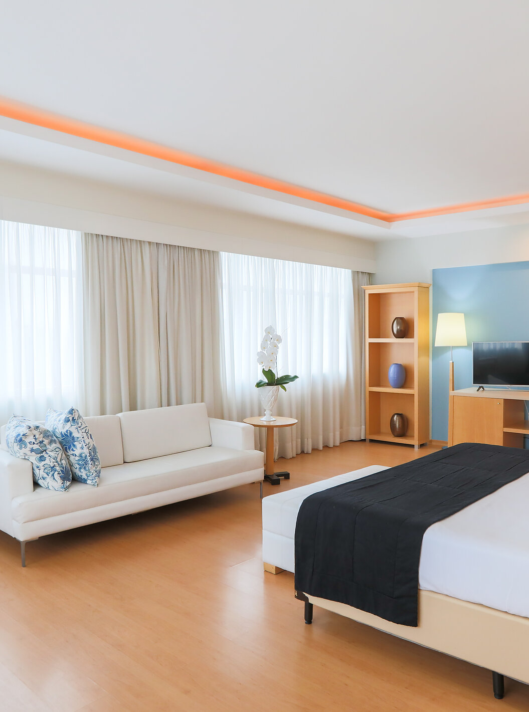 A King Suite Executiva do Pestana Curitiba é um quarto amplo com várias janelas, bastante luminoso, com cama de casal e sofá