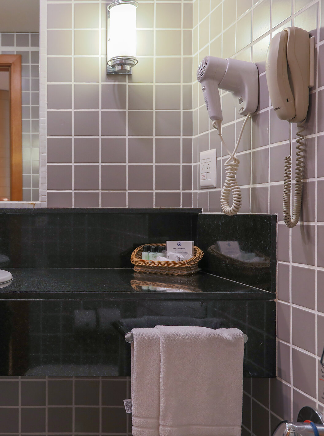 O Queen Superior do Pestana Curitiba tem uma casa de banho com azulejos cinzentos e uma bancada preta com lavatório