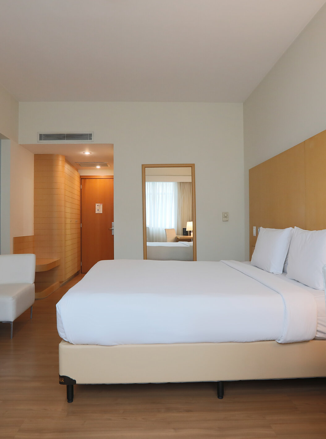 O Queen Superior do Pestana Curitiba tem uma cama de casal e dois sofás individuais ao pés da cama