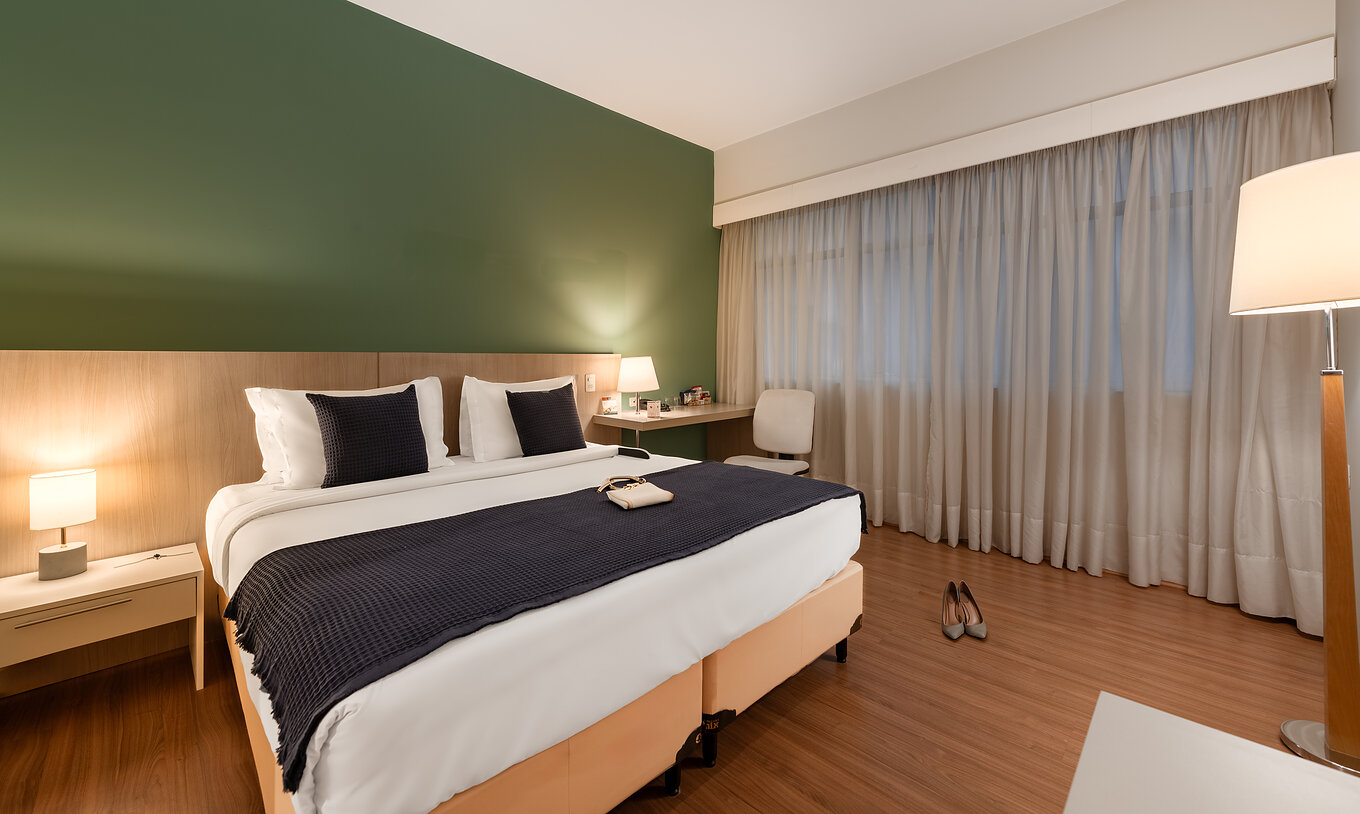 O Superior Adaptado do Pestana Curitiba tem uma cama com uma secretária e uma janela ao lado
