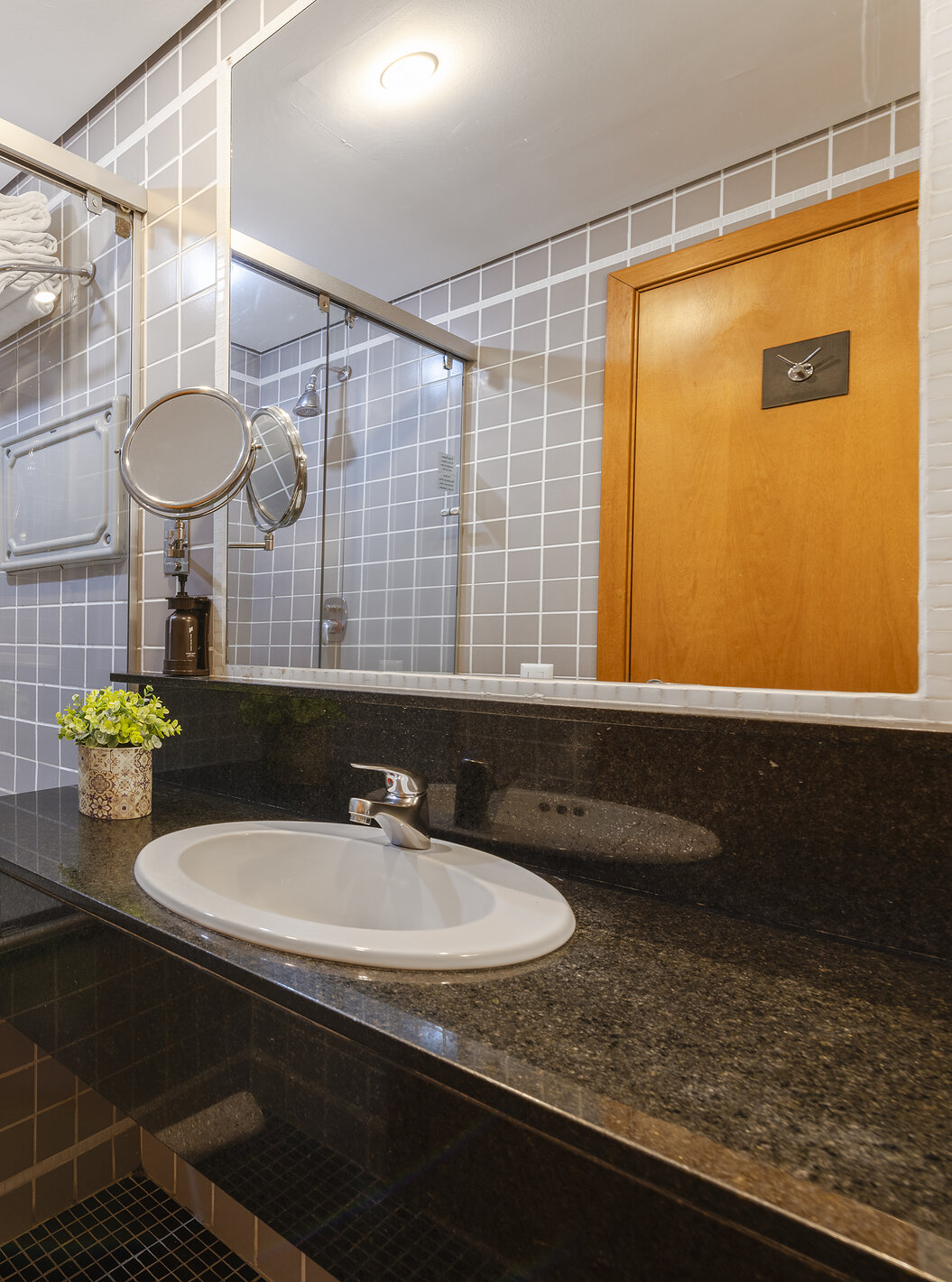 O Twin Superior do Pestana Curitiba tem uma casa de banho com banheira em azulejos cinzentos e bancada com lavatório