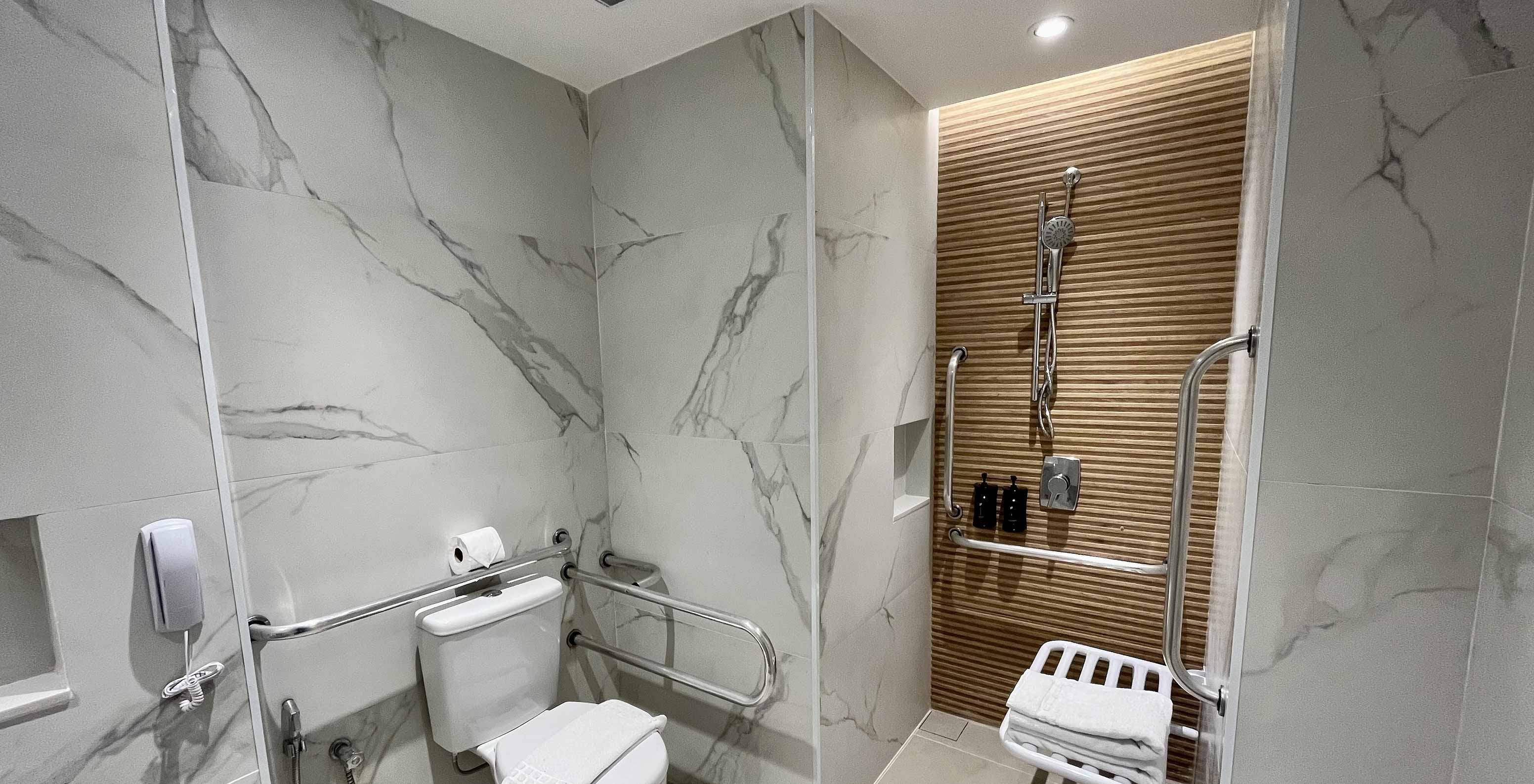 O Quarto Semi Adaptado do Pestana Rio Atlântica tem uma casa de banho acessível com sanita, duche e barras de apoio