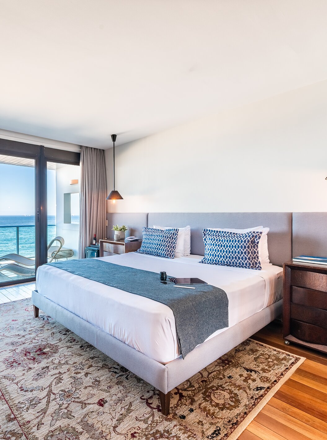 A Suite Presidencial do Pestana Rio Atlântica tem uma decoração moderna, uma cama de casal, poltrona e varanda com vista mar