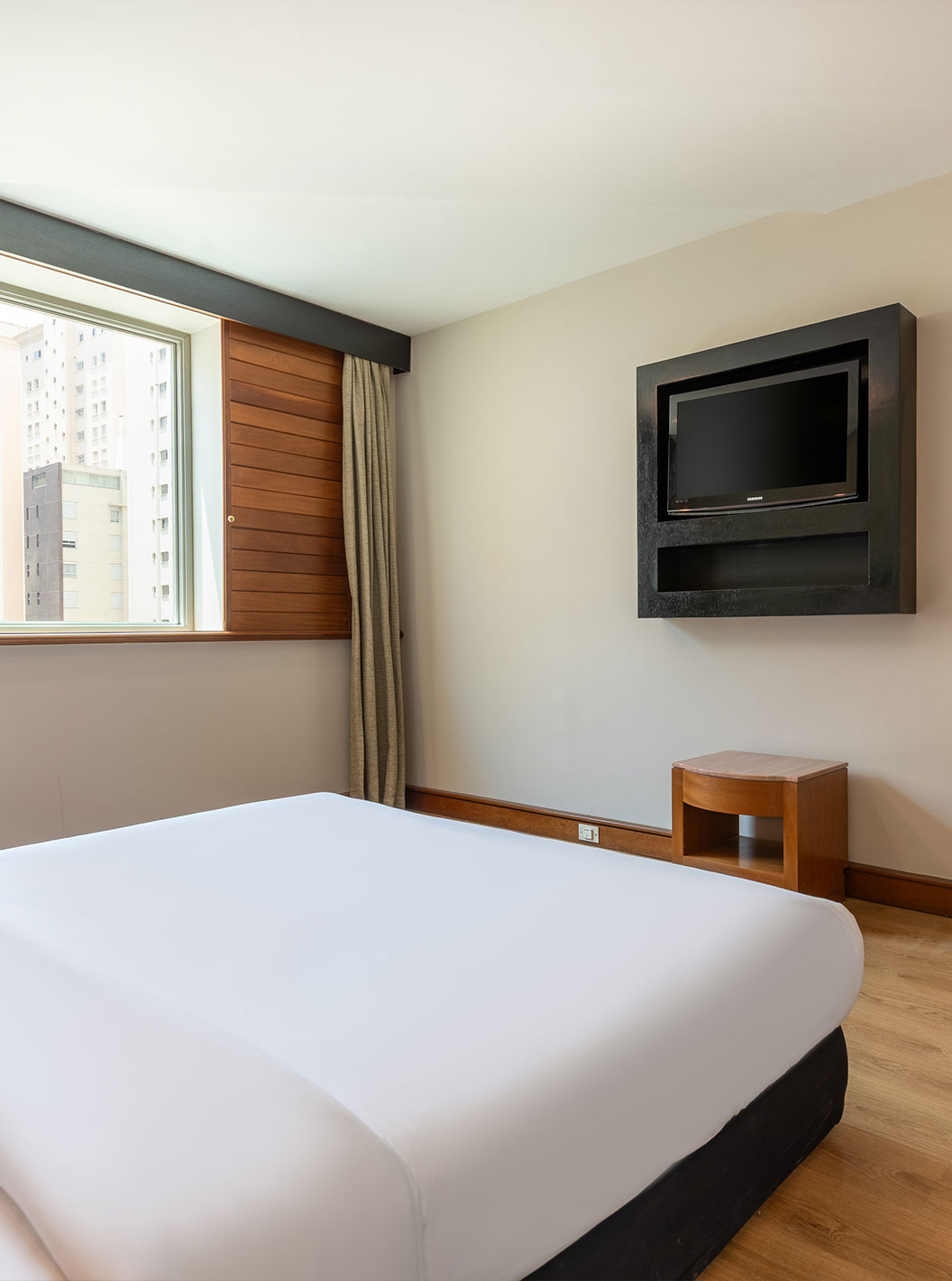 Quarto Standard Adaptado do Pestana São Paulo com cama, secretária, janela ampla e minibar