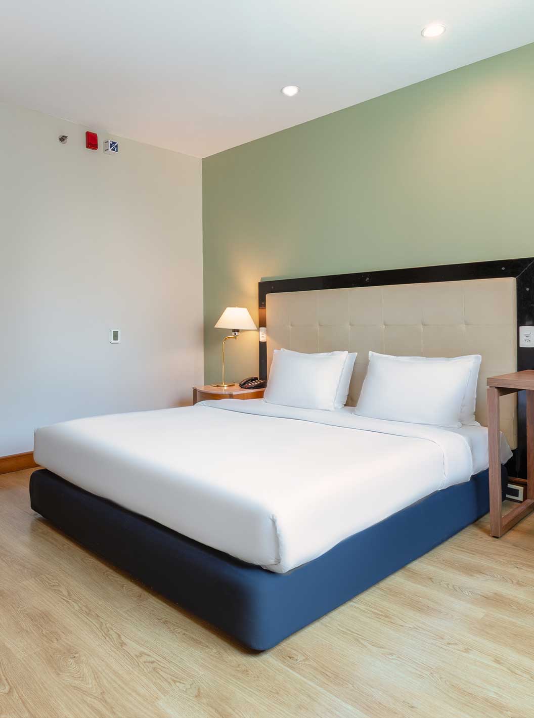 Quarto Standard Adaptado do Pestana São Paulo com cama de casal, secretária de madeira e cadeira de escritório