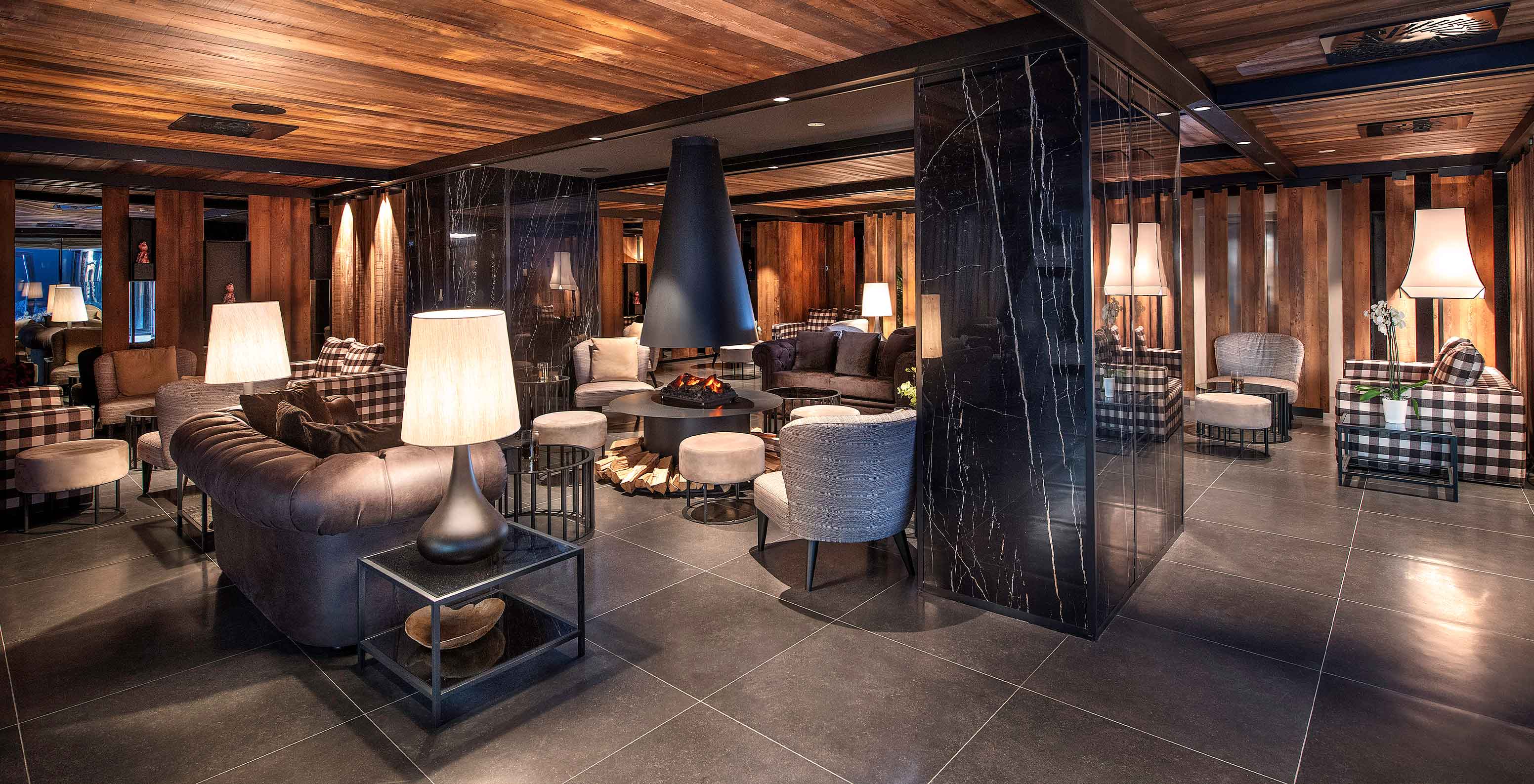 Sala de estar elegante do Le Massif Courmayeur, Hotel nos Alpes Italianos em Courmayeur para fazer ski, com sofás e lareira central