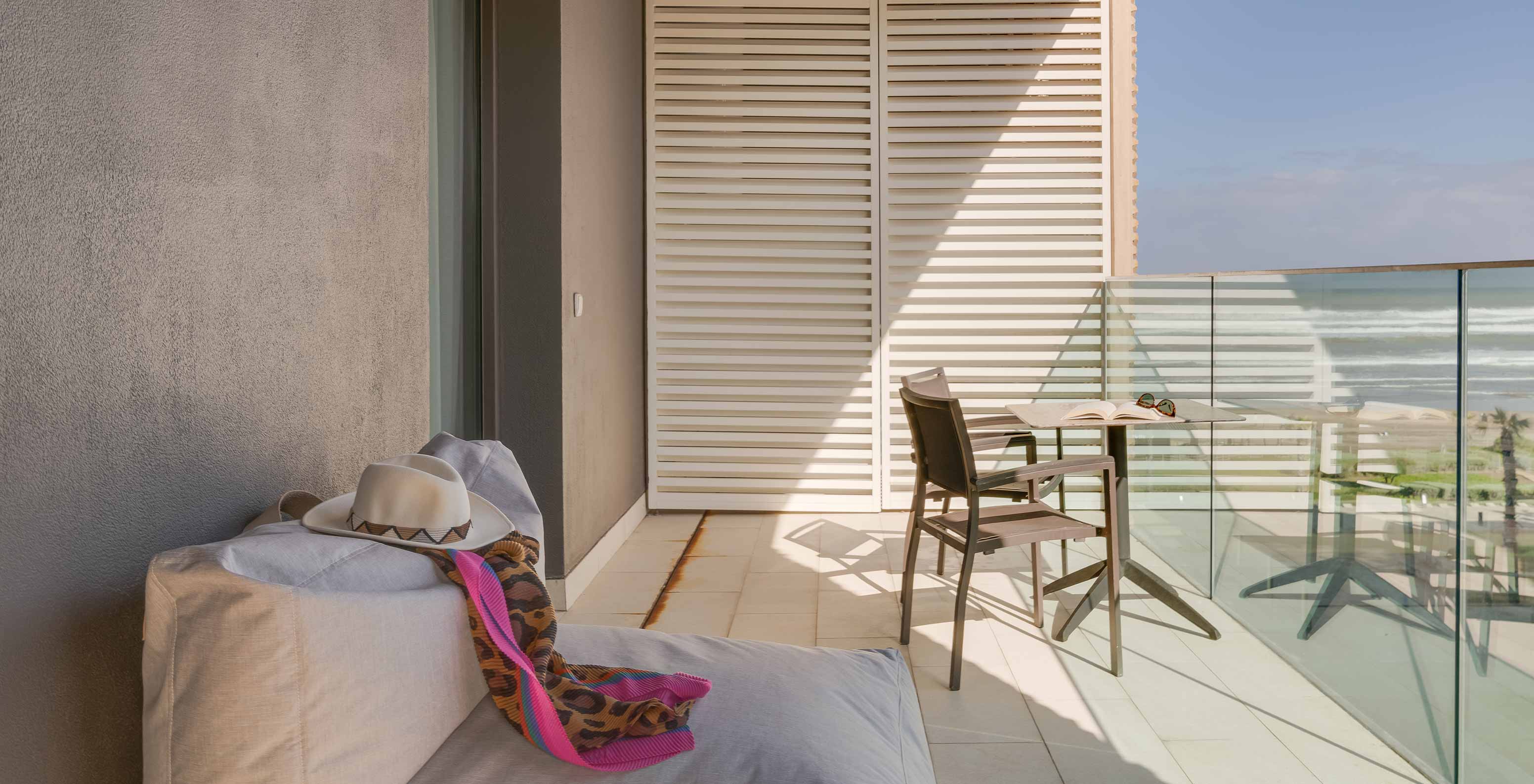 Suite Familiar Premium com Vista Lateral para o Oceano e Varanda no Pestana Casablanca com mesa na varanda