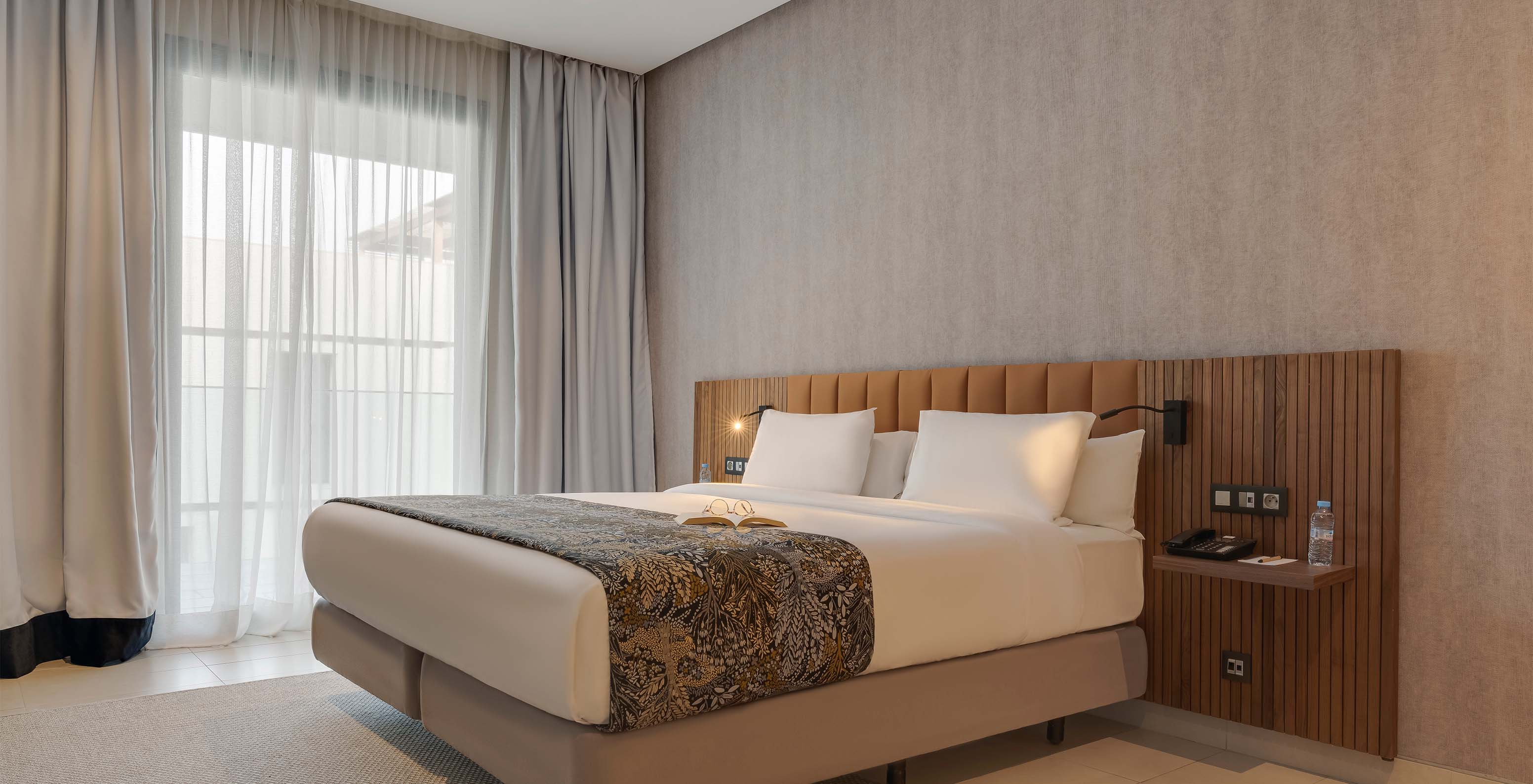 Pestana Casablanca Hotel 4 Estrelas em Casablanca, Marrocos com quarto moderno e cama junto a ampla janela