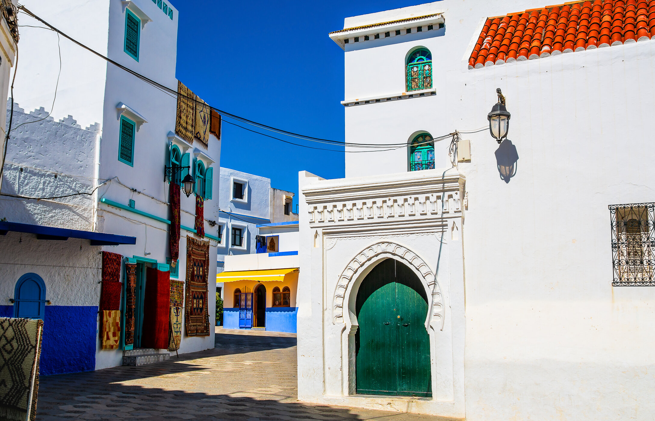 Pelas ruas estreitas de Tânger, é possível passear por recantos coloridos com tapeçaria pendurada
