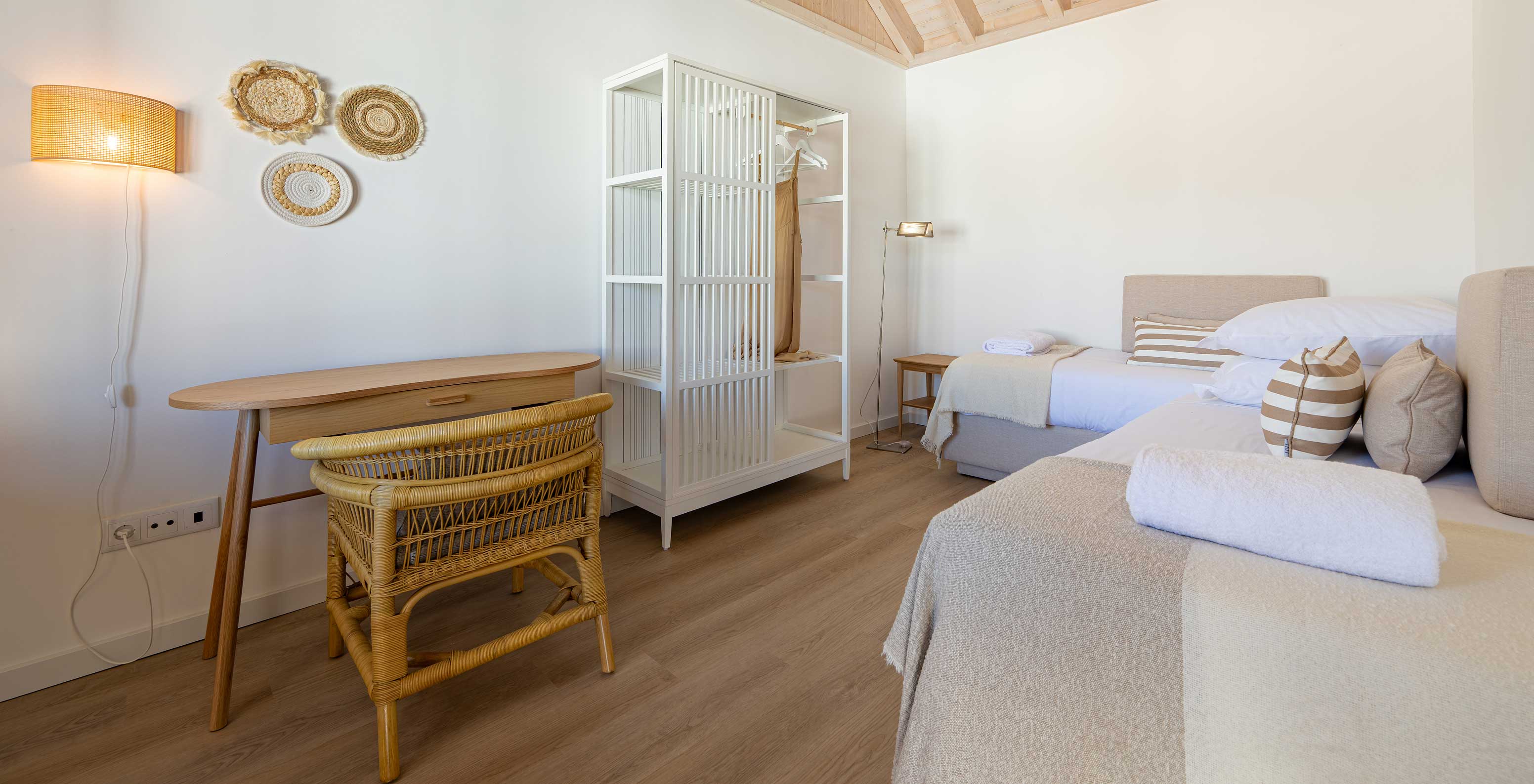 A Standard Villa do Pestana Comporta Village Residences tem um quarto com cama, uma mesa e uma cadeira de vime