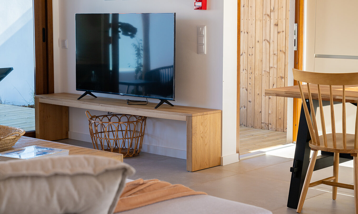 A Superior Green Villa do Pestana Comporta Village Residences tem uma sala moderna com uma TV e móveis de madeira