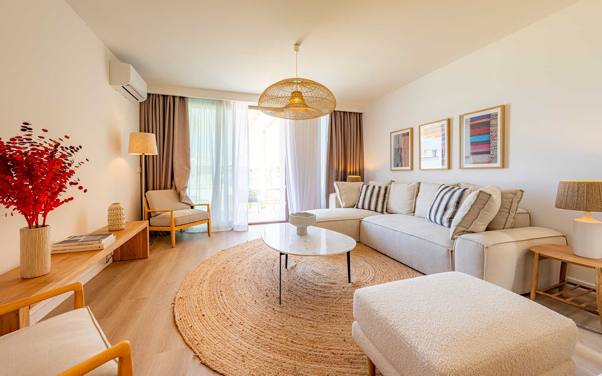 Sala de estar luminosa no Pestana Porto Covo Village, com sofá bege, mesa de centro e decoração moderna